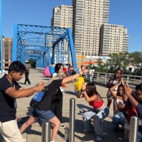 Group of students posing near Blue Bridge pretending to be a fish